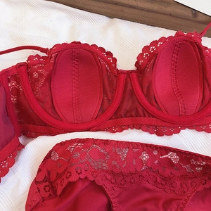 Detailed view of red floral lace lingerie set with soft underwire on white fabric