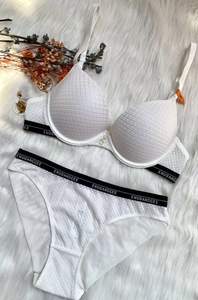 Gros plan d'un ensemble de lingerie en dentelle blanche avec bande logo contrastée