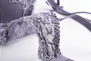 Macro shot of deep purple lace fabric with intricate floral patterns and mesh texture
