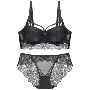 Detailed view of floral black lace bra and matching panty set on white background
