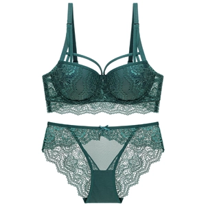 Deep green lace lingerie set with push-up bra and cage straps on a white background