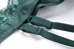 Close-up of adjustable strap and fine dark green lace texture on a push-up bra