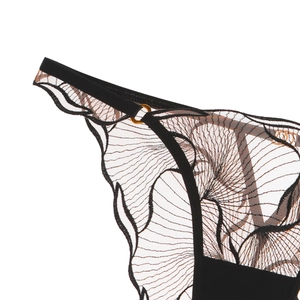 Detail of black lace embroidery with sheer mesh and golden metal buckle on lingerie