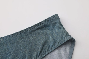 Detail view of denim print texture and zigzag stitching on low-rise seamless panties