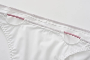 Détail de la culotte sans couture blanche avec bretelles roses et tissu soyeux lisse