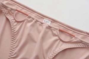 Détail macro de culotte sans couture taille basse rose poudré avec découpes élégantes