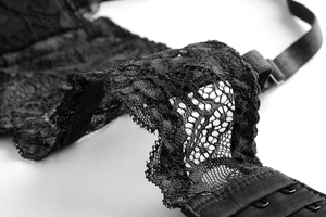 Détail de dentelle florale délicate et bretelles métalliques sur lingerie noire