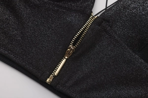 Detail of black glitter fabric with high-quality gold metal zipper for party dress