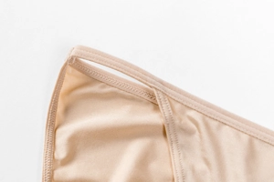 Detail of reinforced seams and silky nude fabric texture on seamless panties