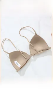 Detailed view of the front buckle closure and thin straps on the seamless beige bra
