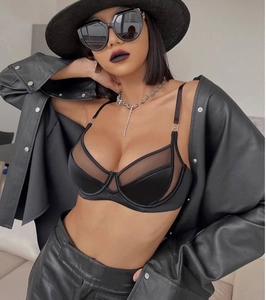 Dettaglio di un reggiseno nero in mesh e seta con ferretto e anelli metallici decorativi