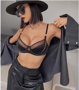 Dettaglio del reggiseno a rete trasparente con fibbie metalliche dorate ed elastici