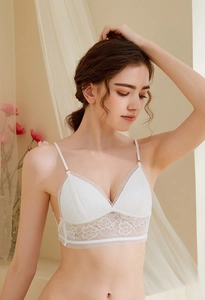 Detail showing white lace bralette with delicate floral embroidery and thin straps