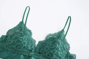 Detail view of dark green lace cups with floral pattern and delicate bow decoration