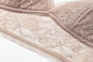 Close-up of delicate lotus pink lace fabric and scalloped edges on French triangle bra