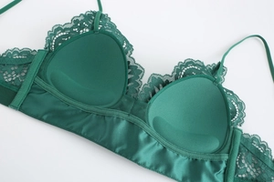 Macro detail of dark green lace bra showing padded inner cup and stitching craftsmanship