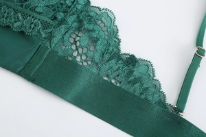 Close-up of deep green eyelash lace and satin straps with rose gold metal adjustment buckles