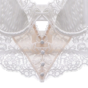Detail of cream lace corset showing satin cups with pleats and eyelash lace trim