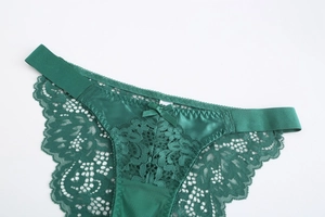 Detail view of emerald green lace panties with satin fabric and a delicate bow decoration