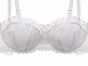 Gros plan sur la broderie de dentelle florale blanche d'un soutien-gorge en résille