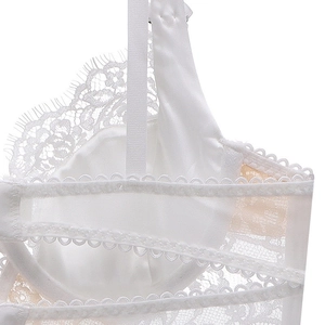 Detail of white eyelash lace embroidery and satin fabric on French style bra