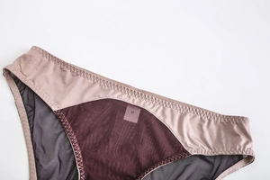 Gros plan détaillé de la culotte en satin rose et tulle violet avec coutures raffinées