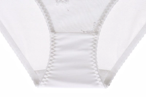 Detail of white lace panty crotch featuring breathable mesh and floral embroidery