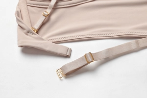Detail of adjustable straps with gold metal buckles on a nude seamless triangle bra