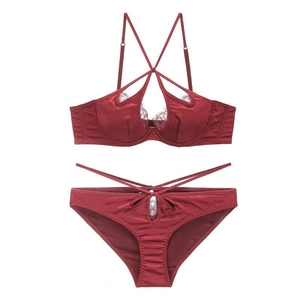 Detail of wine red satin lingerie set featuring intricate eyelash lace and crisscross straps