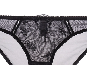 Close-up of black mesh panties featuring intricate floral embroidery and sheer lace detail
