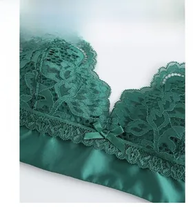 Detail of dark green lace bra showing floral patterns and elegant satin texture