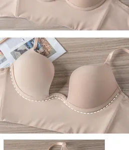 Detail of a beige seamless push-up bra with a deep U-shape back on a wooden desk