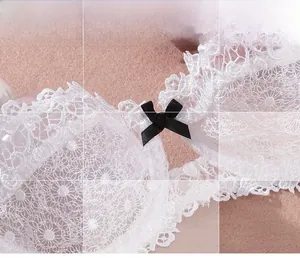 Close-up detail of white floral embroidery lace bra with a black satin bow accent