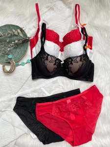 Flat lay of elegant lace embroidery bra sets in red, white and black colors