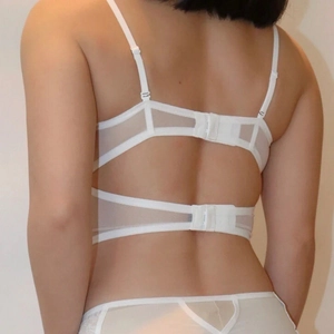 Detailed back view of white lace corset bra featuring adjustable straps and hook-and-eye closure