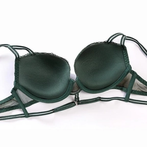 Detail view of dark green bra featuring smooth cups and intricate lace side wings