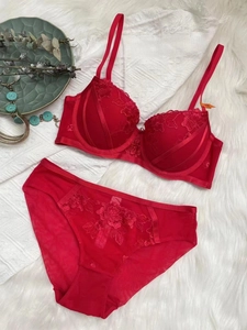 Flat lay of red lace lingerie set featuring floral embroidery and adjustable straps
