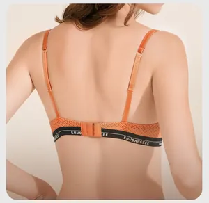 Detail of orange mesh bra featuring elastic logo band and adjustable shoulder straps