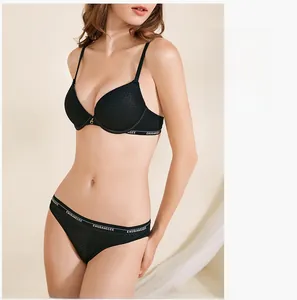 Detail of black lace bra set with gold buckle and lettered logo elastic band