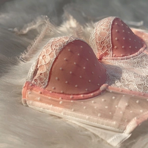 Pink French lace push-up bra with white polka dots and delicate bow detail on fur background
