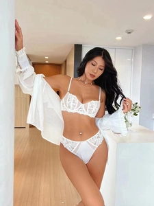 Close-up detail of white lace lingerie set featuring delicate embroidery and mesh panels