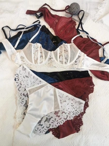 Flat lay of lace lingerie sets with underwire bras and matching panties in various colors