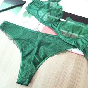 Deep green lace lingerie set with underwire bra and thong on a wooden background