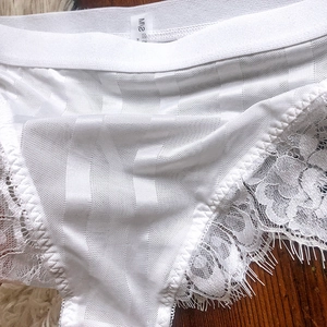 Detail of white eyelash lace panties showing mesh texture and elastic waistband