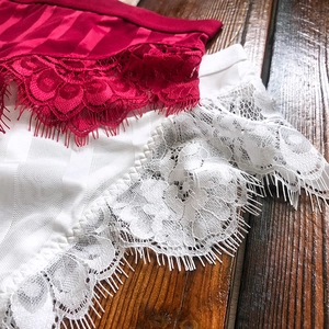 Detailed macro shot of sheer eyelash lace edges and vertical striped fabric on panties