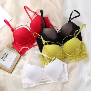 Mise à plat de quatre soutiens-gorge en dentelle rouge noir jaune blanc à broderie