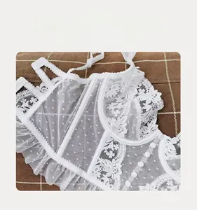 Détail de la dentelle française blanche montrant le tulle floral et les boutons fins