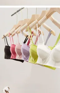 Detail of colorful seamless bras on wooden hangers showing textured fabric and straps