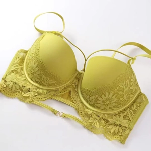 Gros plan du soutien-gorge en dentelle jaune fluo avec motifs floraux et fines bretelles