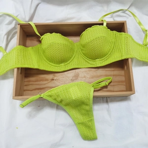 Detailed macro view of the semi-cup lace bra and thong set in bright yellow lace fabric